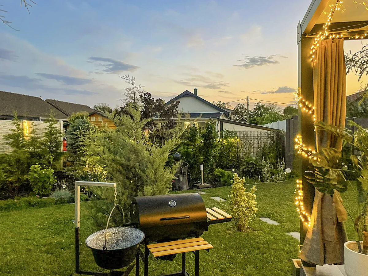 Kerti grill a fedett terasz mellett, lágy alkonyati fényben