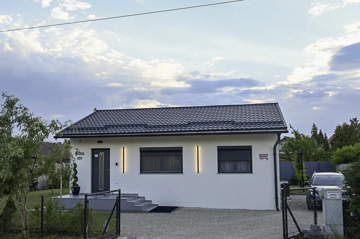 A MeTime Balaton vendégház bejárati homlokzata szürkületben